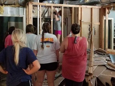 Team members help construct a home