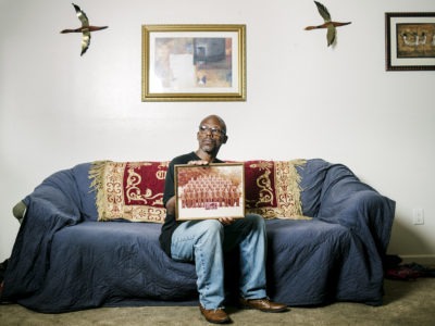 Man sitting on couch holding photo