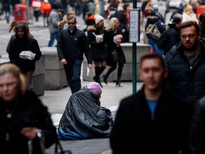 People on busy street around person experiencing homelessness