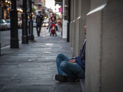 Person sitting on the ground on a street