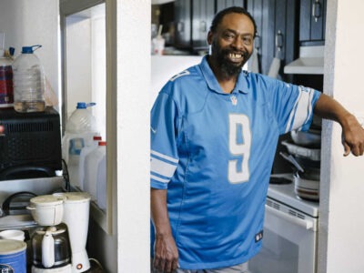 Man smiling in an apartment kitchen